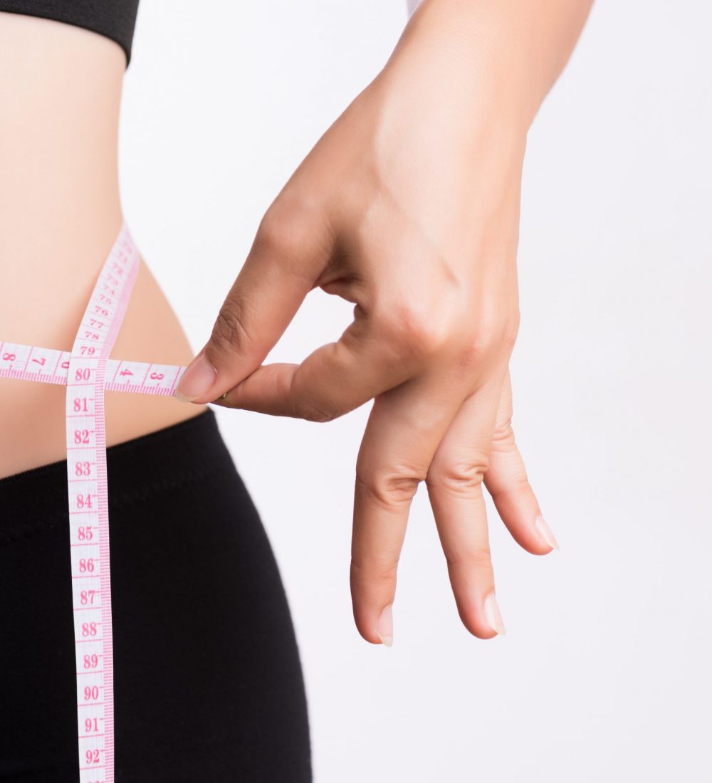 Fat woman hand measuring waist with white measuring tape, reducing excess weight. Healthcare and sport concept.